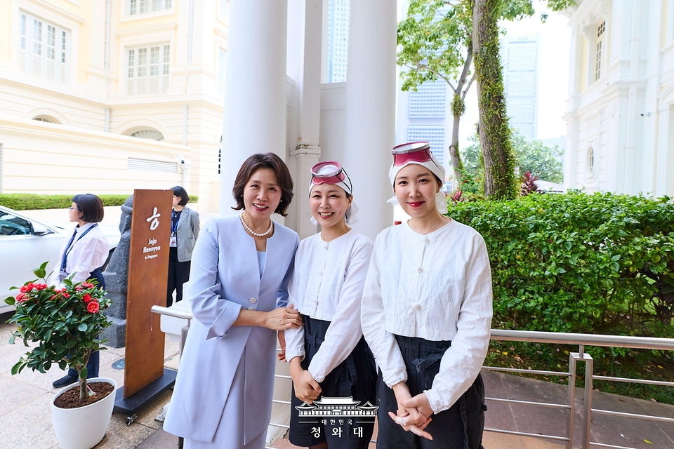 이재명 대통령과 싱가포르를 국빈방문 중인 김혜경 여사가 3월 2일(현지 시간) '해녀의 부엌 싱가포르점'에서 한국관광 현장 간담회 후 공연단과 기념촬영을 하고 있다. '해녀의 부엌'은 제주 음식을 맛보며 사물놀이 연주를 함께 감상할 수 있는 복합 공연장이다.