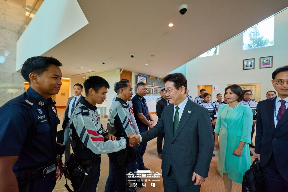 싱가포르 국빈 방문 일정을 마친 이재명 대통령과 김혜경 여사가 3일(현지 시간) 필리핀 국빈 방문을 위해 창이 국제공항에서 출국하며 공항 직원들과 악수하고 있다.