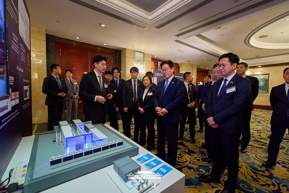 이재명 대통령이 3월 2일(현지 시간) 싱가포르의 한 호텔에서 열린 한-싱가포르 AI 커넥트 서밋이 끝난 뒤 한 전시 업체 관계자로부터 AI 반도체 제품 상용화 사례에 대한 설명을 듣고 있다.
