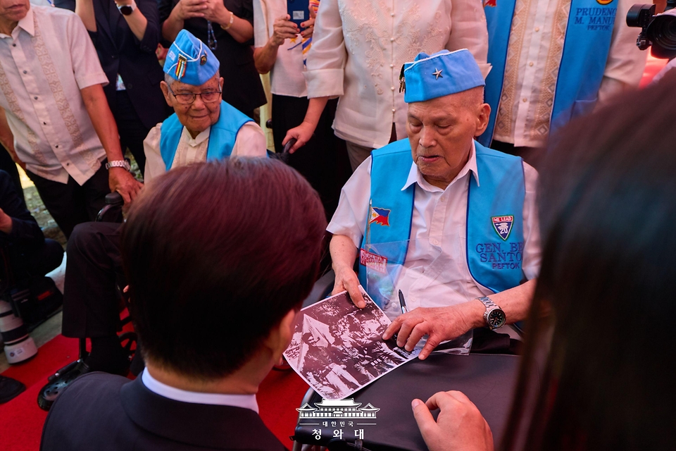필리핀을 국빈방문 중인 이재명 대통령이 3월 4일(현지 시간) 마닐라 영웅묘지에서 한국전 참전 기념비를 방문해 헌화를 마친 뒤 참전용사와 대화하고 있다.
