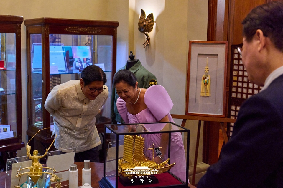 페르디난드 마르코스 필리핀 대통령과 루이즈 아라네타 마르코스 영부인이 3월 3일(현지 시간) 필리핀 마닐라 말라카냥궁에서 이재명 대통령 국빈방문 공식 만찬에 앞서 이 대통령이 선물한 금 거북선 모형을 보고 있다.