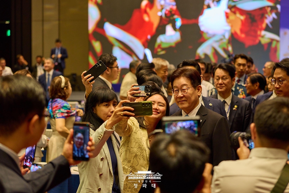 이재명 대통령이 3월 4일(현지 시간) 필리핀 마닐라 콘래드 호텔에서 열린 한-필리핀 비즈니스 포럼에서 참석자와 셀피 사진을 찍고 있다.