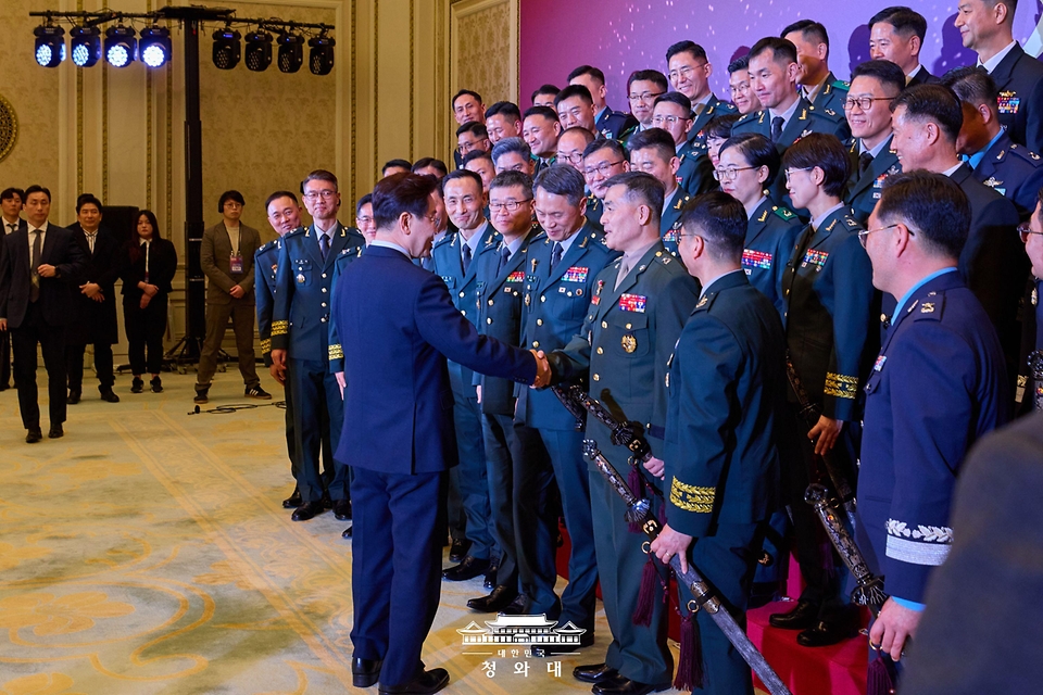 이재명 대통령이 3월 6일 청와대 영빈관에서 열린 2026년 준장 진급 장성 삼정검 수여식에서 기념촬영을 마친 뒤 박정훈 국방부 조사본부장과 악수하고 있다.