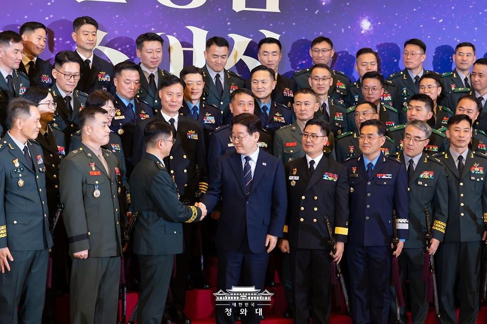 이재명 대통령이 3월 6일 청와대 영빈관에서 열린 2026년 준장 진급 장성 삼정검 수여식에서 기념촬영을 마친 뒤 진급자들과 악수하고 있다.