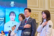 이재명 대통령과 김혜경 여사가 3월 5일 청와대 영빈관에서 열린 2026 밀라노-코르티나담페초 동계올림픽 선수단 격려 오찬에서 국기에 경례하고 있다.