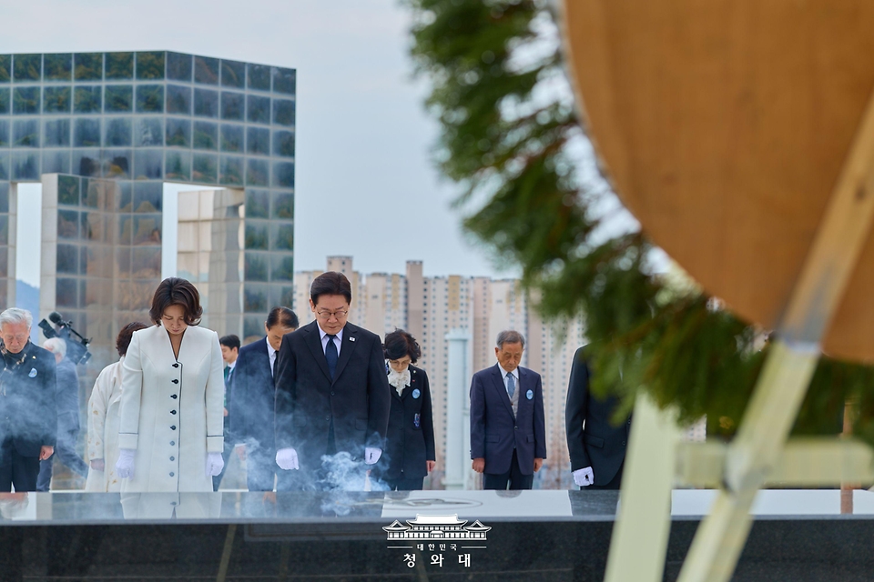 이재명 대통령과 김혜경 여사가 3월 15일 경남 창원시 마산회원구 국립 3·15 민주 묘지에서 분향 후 묵념하고 있다.