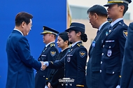 이재명 대통령이 3월 17일 충남 아산 경찰대학에서 열린 2026년 신임 경찰 경위·경감 임용식에서 임용자 대표 이주영 경위에게 계급장을 달아준 뒤 악수하고 있다.