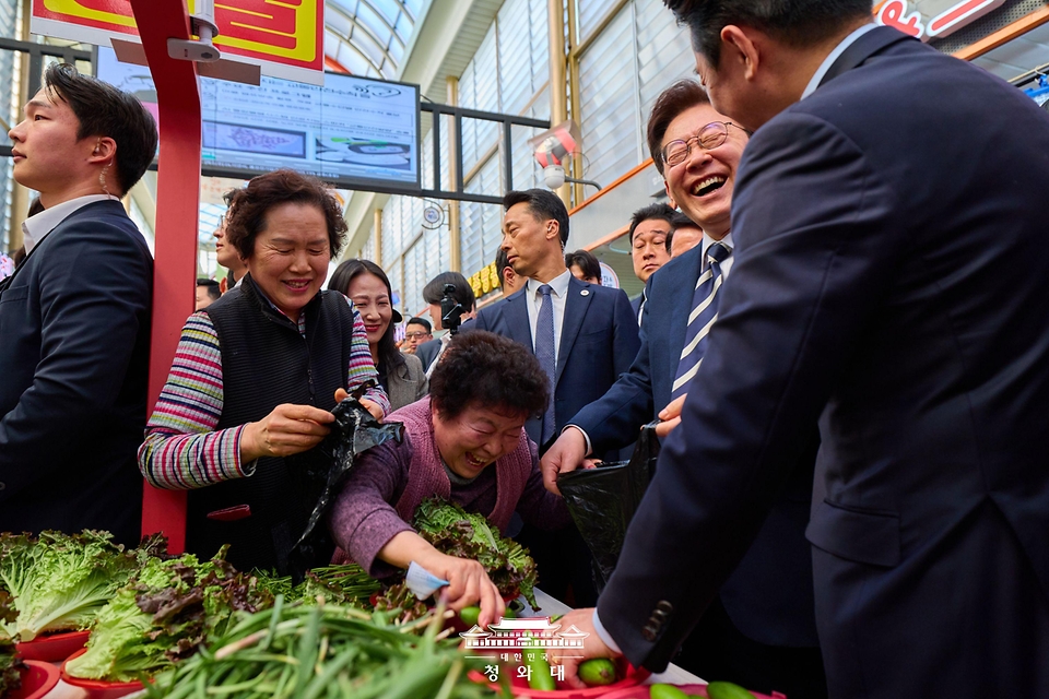 이재명 대통령이 3월 25일 한국항공우주산업(KAI)에서 열린 KF-21 양산 1호기 출고식에 참석한 뒤 경남 진주시 진주중앙시장을 방문해 상인과 대화를 나누고 있다.