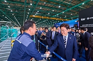 이재명 대통령이 3월 25일 경남 사천 한국항공우주산업(KAI)에서 KF-21 양산 1호기 출고식 후 생산시설을 시찰하며 관계자들과 악수하고 있다.