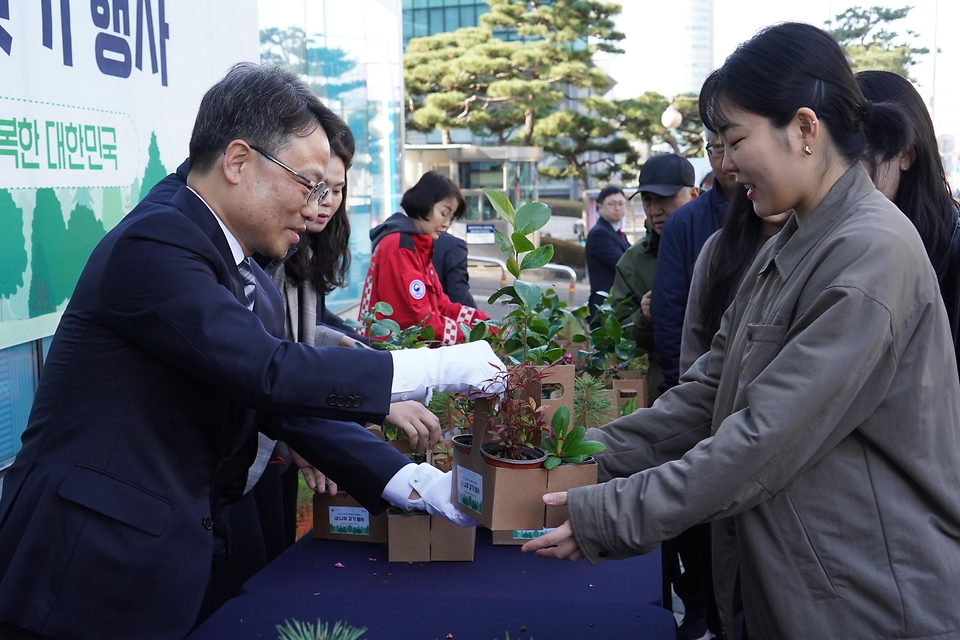 박은식 산림청장이 3월 25일 서울 중구 문화일보 사옥에서 열린 '2026 산림청과 문화일보가 함께하는 내나무 갖기 행사'에서 이병규 문화일보 회장과 함께 시민들에게 묘목을 나눠주고 있다.
