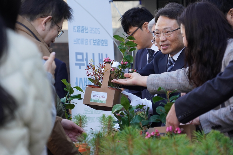 박은식 산림청장이 3월 25일 서울 중구 문화일보 사옥에서 열린 '2026 산림청과 문화일보가 함께하는 내나무 갖기 행사'에서 이병규 문화일보 회장과 함께 시민들에게 묘목을 나눠주고 있다.