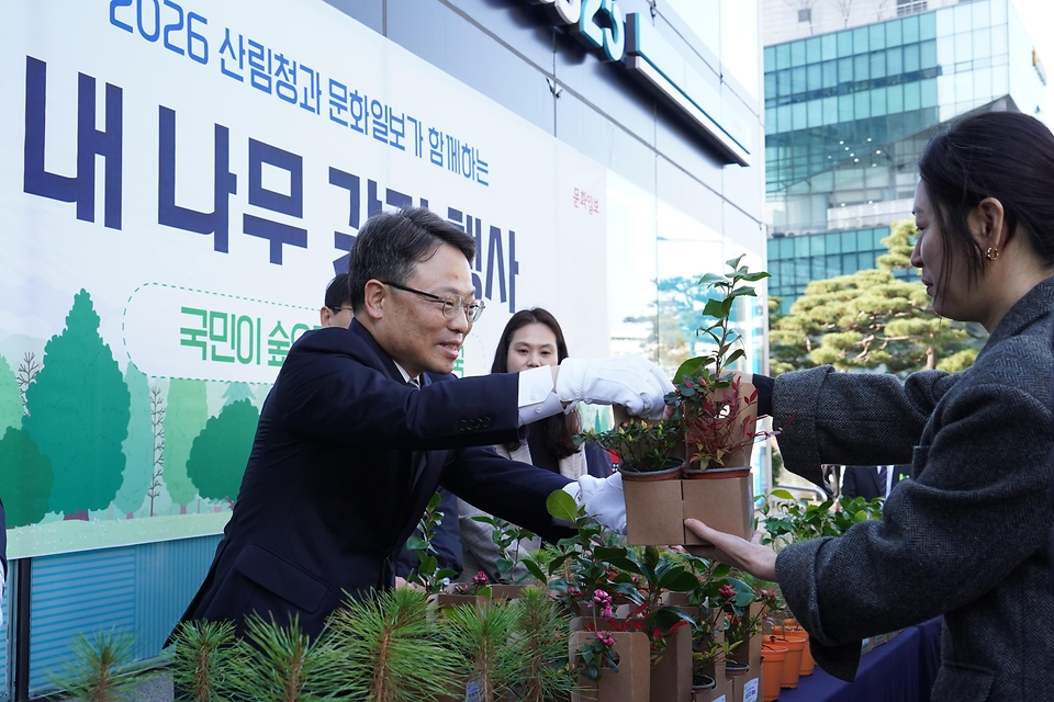 박은식 산림청장이 3월 25일 서울 중구 문화일보 사옥에서 열린 '2026 산림청과 문화일보가 함께하는 내나무 갖기 행사'에서 이병규 문화일보 회장과 함께 시민들에게 묘목을 나눠주고 있다.