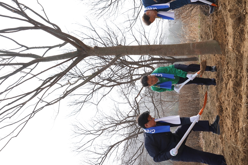 3월 27일 경기도 용인시 처인구에서 열린 '탄소흡수원 확충을 위한 민간참여 나무심기'에서 참가자들이 나무를 심고 있다.