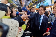 이재명 대통령이 3월 30일 제주 타운홀미팅을 마친 뒤 김혜경 여사와 함께 제주시 동문시장을 찾아 방문객들과 악수하고 있다.
