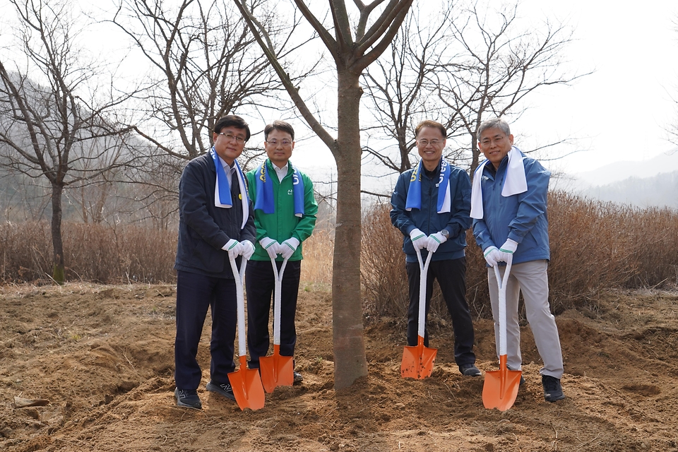 3월 27일 경기도 용인시 처인구에서 열린 '탄소흡수원 확충을 위한 민간참여 나무심기'에서 참가자들이 나무를 심고 있다.