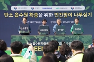 3월 27일 경기도 용인시 처인구에서 열린 '탄소흡수원 확충을 위한 민간참여 나무심기'에서 참가자들이 나무를 심고 있다.