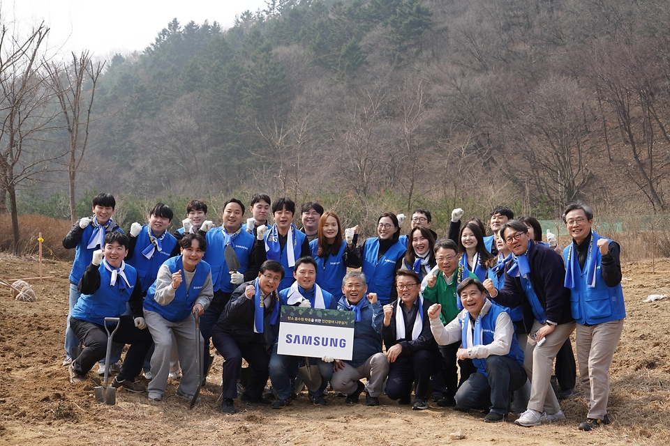 3월 27일 경기도 용인시 처인구에서 열린 '탄소흡수원 확충을 위한 민간참여 나무심기'에서 참가자들이 나무를 심고 있다.