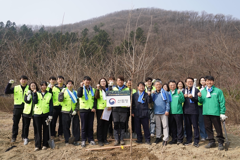 3월 27일 경기도 용인시 처인구에서 열린 '탄소흡수원 확충을 위한 민간참여 나무심기'에서 참가자들이 나무를 심고 있다.