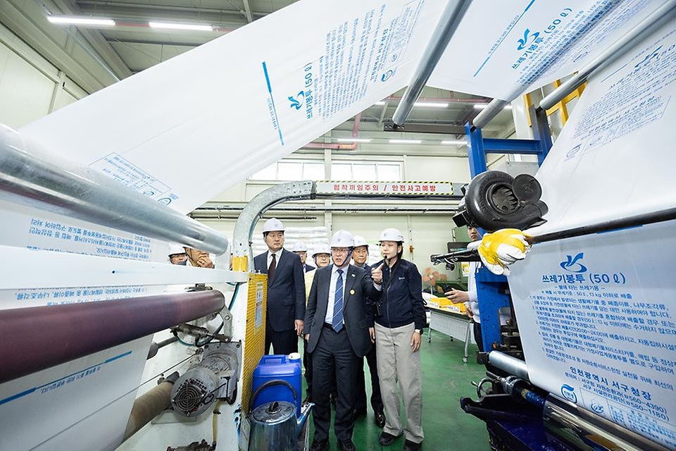 김성환 기후에너지환경부 장관이 4월 3일 쓰레기봉투를 생산하는 인천광역시 서구 구립장애인직업재활시설을 방문해 쓰레기봉투 생산 과정과 재생원료를 활용한 봉투를 비교해 보고 쓰레기봉투 수급 및 재고 현황과 현 상황에 대한 의견을 나누고 있다.