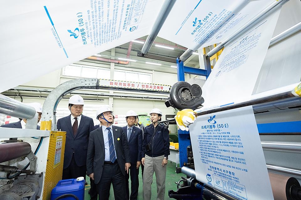 김성환 기후에너지환경부 장관이 4월 3일 쓰레기봉투를 생산하는 인천광역시 서구 구립장애인직업재활시설을 방문해 쓰레기봉투 생산 과정과 재생원료를 활용한 봉투를 비교해 보고 쓰레기봉투 수급 및 재고 현황과 현 상황에 대한 의견을 나누고 있다.