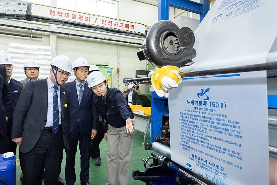 김성환 기후에너지환경부 장관이 4월 3일 쓰레기봉투를 생산하는 인천광역시 서구 구립장애인직업재활시설을 방문해 쓰레기봉투 생산 과정과 재생원료를 활용한 봉투를 비교해 보고 쓰레기봉투 수급 및 재고 현황과 현 상황에 대한 의견을 나누고 있다.