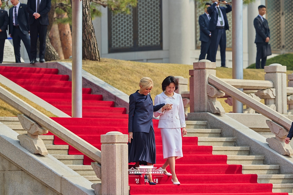김혜경·브리지트 마크롱 여사가 4월 3일 오전 청와대에서 열린 프랑스 대통령 내외 공식 환영식에서 손을 잡고 이동하고 있다.