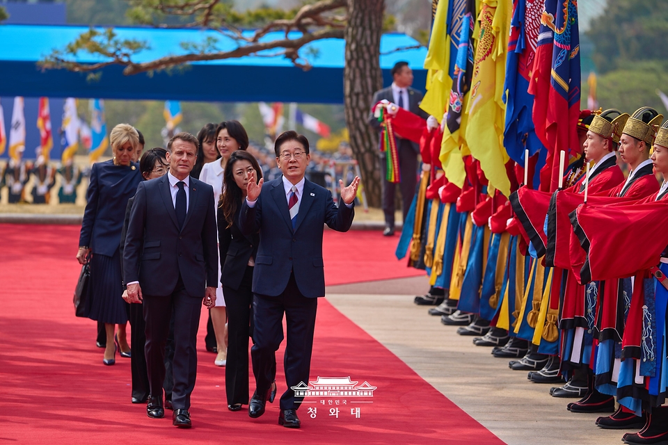 이재명 대통령과 에마뉘엘 마크롱 프랑스 대통령이 4월 3일 청와대에서 열린 국빈 방한 공식 환영식에서 프랑스 측 수행원 인사를 위해 이동하며 대화하고 있다.