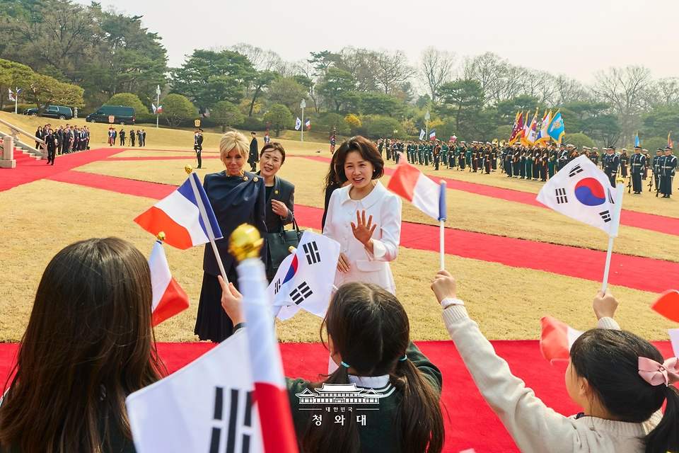 김혜경 여사와 에마뉘엘 마크롱 프랑스 대통령 부인 브리지트 마크롱 여사가 4월 3일 청와대에서 열린 공식 환영식에서 어린이들에게 인사를 하고 있다.