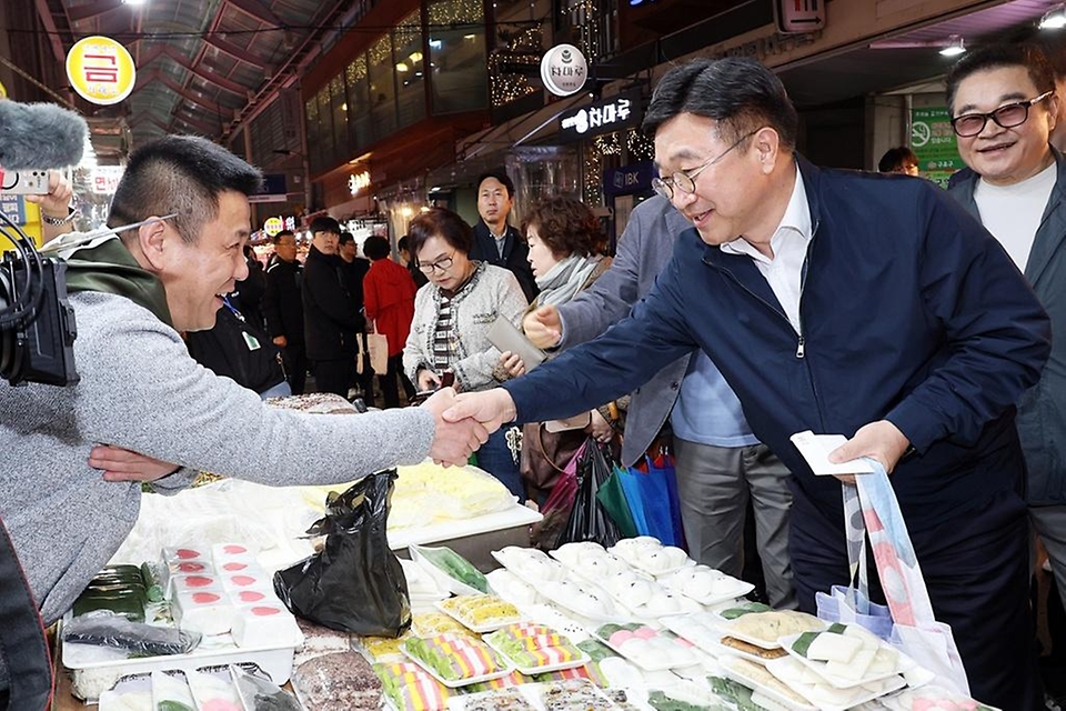 윤호중 행정안전부 장관이 4월 9일 서울 남구로시장을 방문해 비상경제대응 시장 물가 점검 등 물품 구매하며 상인들을 격려하고 있다.