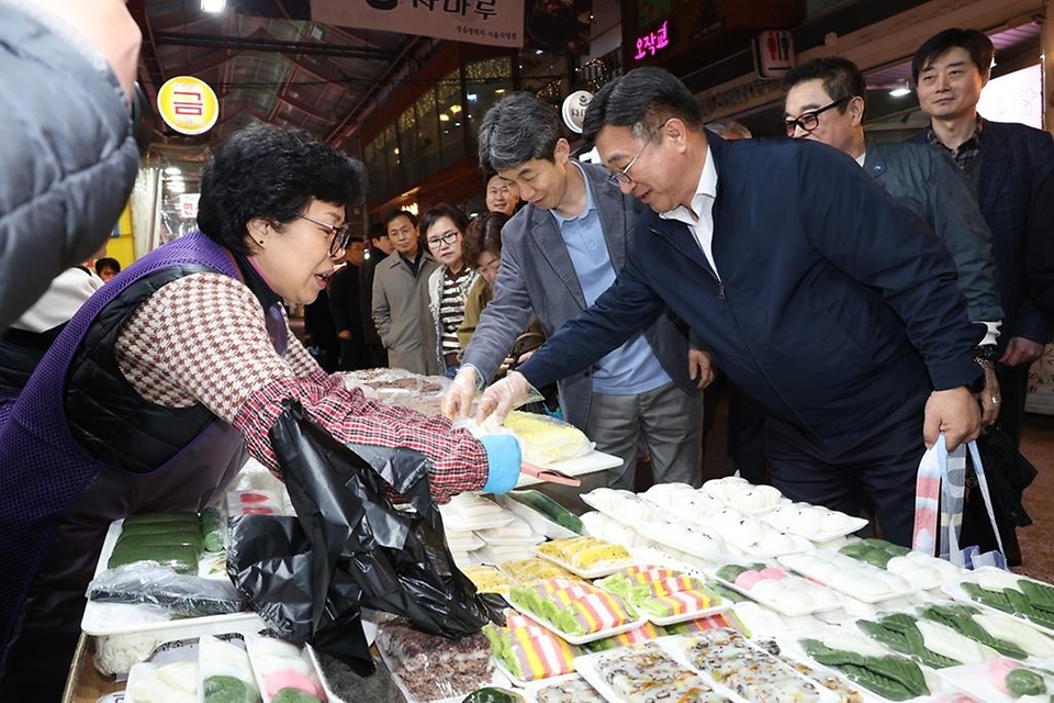 윤호중 행정안전부 장관이 4월 9일 서울 남구로시장을 방문해 비상경제대응 시장 물가 점검 등 물품 구매하며 상인들을 격려하고 있다.