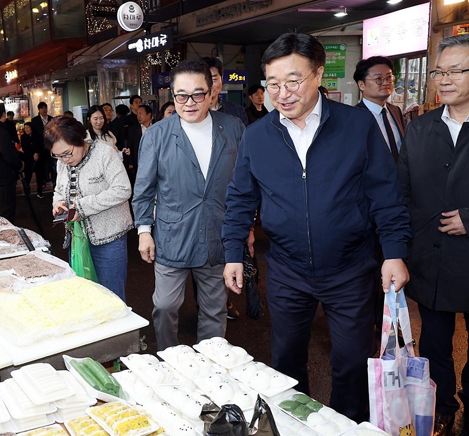 윤호중 행정안전부 장관이 4월 9일 서울 남구로시장을 방문해 비상경제대응 시장 물가 점검 등 물품 구매하며 상인들을 격려하고 있다.