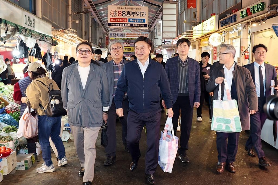 윤호중 행정안전부 장관이 4월 9일 서울 남구로시장을 방문해 비상경제대응 시장 물가 점검 등 물품 구매하며 상인들을 격려하고 있다.