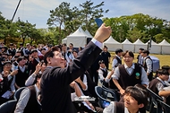 이재명 대통령이 4월 19일 서울 강북구 국립4·19민주묘지에서 열린 제66주년 4·19 혁명 기념식에서 학생들과 셀카를 찍고 있다.