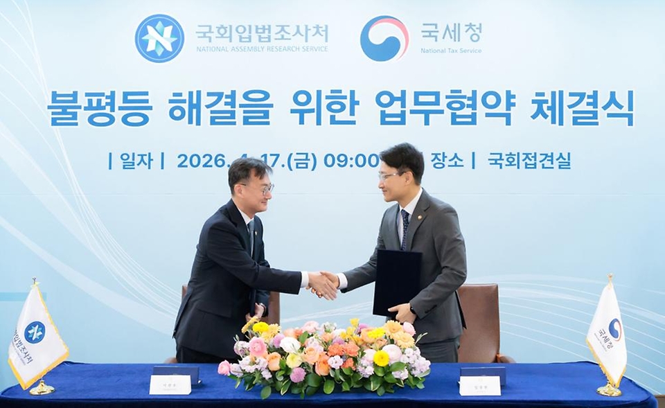임광현 국세청장이 4월 17일 국회접견실에서 열린 불평등 해결을 위한 국세청-국회입법조사처 업무협약 체결식에서 협약서에 서명을 하고, 우원식 국회의장, 이관후 국회입법조사처장을 비롯한 관계자들과 기념촬영을 하고 있다.