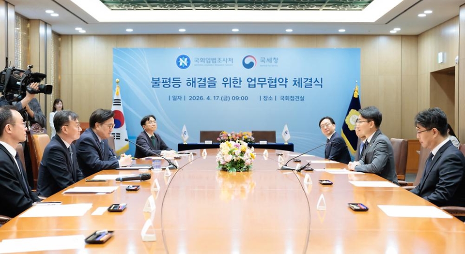 임광현 국세청장이 4월 17일 국회접견실에서 열린 불평등 해결을 위한 국세청-국회입법조사처 업무협약 체결식에서 협약서에 서명을 하고, 우원식 국회의장, 이관후 국회입법조사처장을 비롯한 관계자들과 기념촬영을 하고 있다.