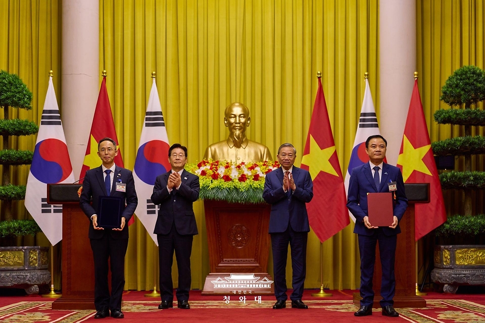황기연 한국수출입은행 은행장과 레 응옥 썬 베트남 국가산업에너지공사(PVN) 회장이 4월 22일(현지 시간) 하노이 주석궁에서 이재명 대통령과 또 럼 공산당 서기장 겸 국가주석이 임석한 가운데 원전 프로젝트 금융 협력 가능성 검토 양해각서(MOU) 교환 후 기념촬영을 하고 있다.