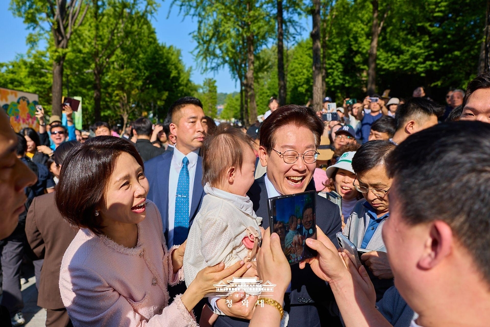 이재명 대통령과 김혜경 여사가 5월 5일 서울 광진구 어린이대공원을 방문해 한 어린이를 품에 안고 기념촬영을 하고 있다.