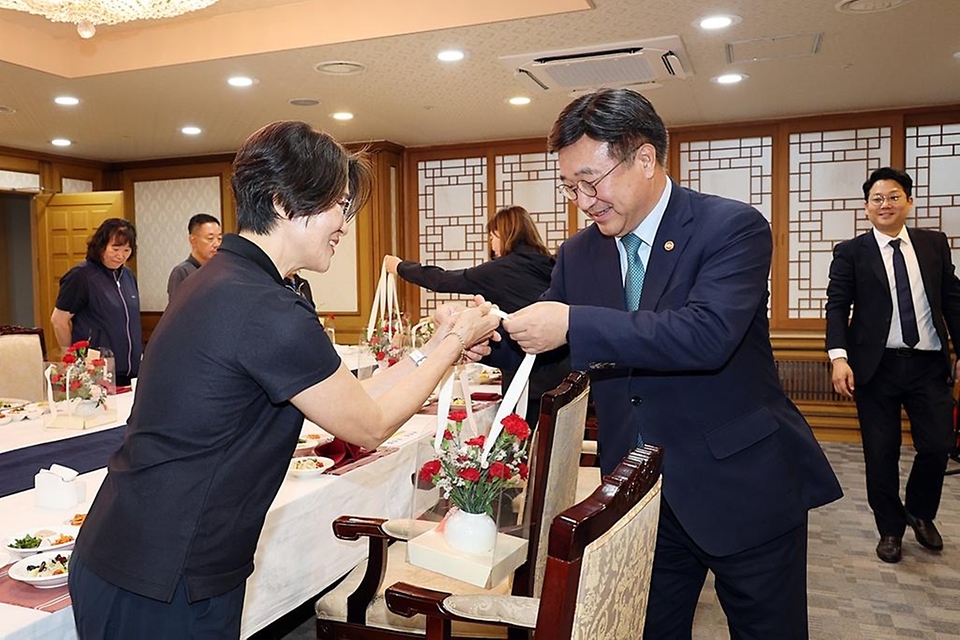 윤호중 행정안전부 장관이 5월 8일 어버이날을 맞아 정부서울청사 환경실무원들을 격려하는 오찬 간담회에서 카네이션을 전달하고 있다.