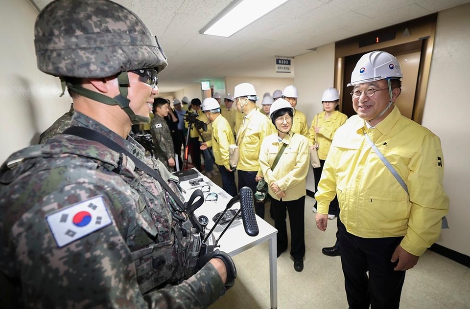 윤호중 행정안전부 장관이 5월 12일 서울 종로구 정부서울청사에서 열린 ‘2026년 5월 공습대비 민방위 훈련’에서 대테러 및 화생방 대응 장비에 대한 설명을 듣고 있다.