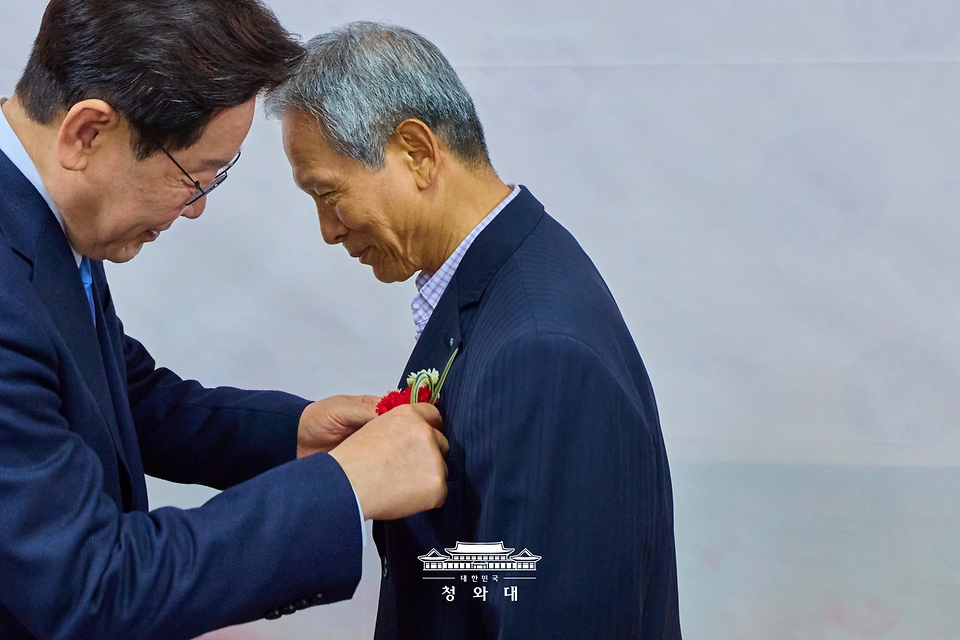 이재명 대통령이 5월 15일 경북 안동의 한 식당에서 이 대통령 모교에서 담임을 맡았던 은사 박병기 선생님과 오찬을 하며 카네이션을 달아주고 있다.