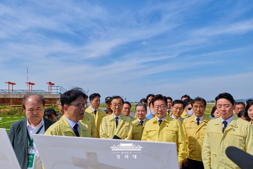 이재명 대통령이 5월 18일 전남 무안국제공항 제주항공 참사 유해 수습현장에서 진행상황 설명을 듣고 있다.