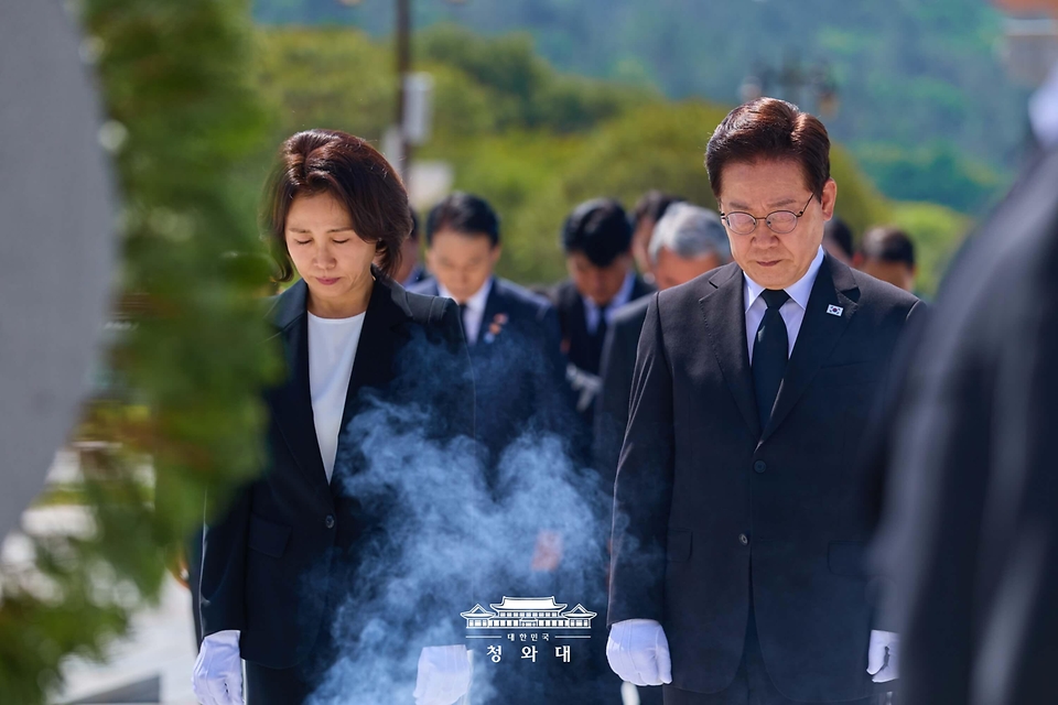 이재명 대통령과 김혜경 여사가 5월 18일 광주 북구 5·18 민주묘지 추모탑에 헌화 뒤 묵념하고 있다.