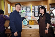 윤호중 행정안전부 장관이 고유가지원금 2차 신청 둘째 날인 5월 19일 오전 서울 영등포구 문래동 지역소비자생활협동조합 매장을 찾아 사용가능 매장 스티커를 부착하고 있다.