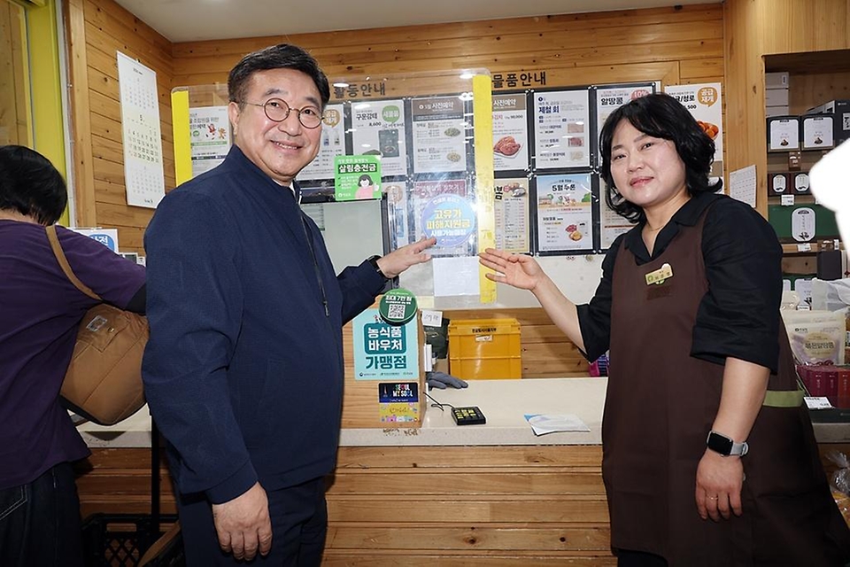 윤호중 행정안전부 장관이 고유가지원금 2차 신청 둘째 날인 5월 19일 오전 서울 영등포구 문래동 지역소비자생활협동조합 매장을 찾아 사용가능 매장 스티커를 부착하고 있다.