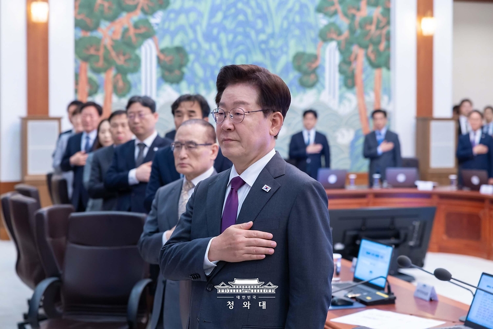 이재명 대통령이 5월 21일 청와대에서 열린 수석보좌관회의에서 국기에 경례하고 있다.