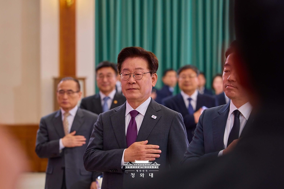 이재명 대통령이 5월 21일 청와대에서 열린 대통령 자문회의·위원회 간담회에서 국기에 경례하고 있다.