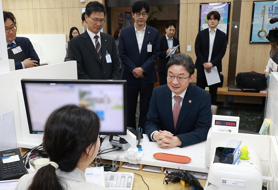 이억원 금융위원장이 5월 22일 국민참여형 국민성장펀드 판매처 중 하나인 서울 종로구 NH농협은행 정부서울청사지점을 방문해 펀드 가입 과정의 전반을 직접 경험하며, 가입 절차상의 편의성과 애로사항 등을 점검한 후 펀드 가입서류에 서명하고 있다.