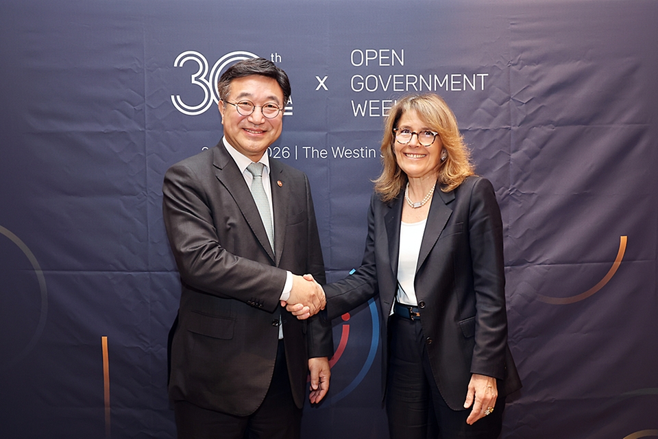 윤호중 행정안전부 장관이 5월 22일 서울 중구 웨스틴조선 호텔에서 열린 2026 OECD 열린정부 국제심지엄에서 파브리찌아 라페코렐라 OECD 사무차장과 환담한 뒤 악수하고 있다.