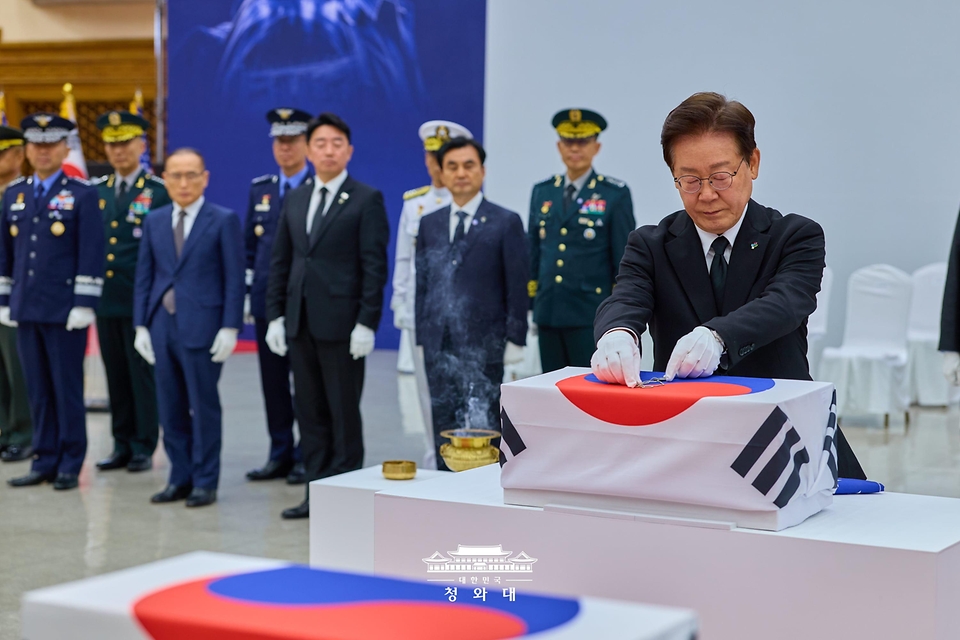 이재명 대통령이 6월 5일 성남 서울공항에서 열린 한·미 6·25전사자 유해 상호봉환식에서 봉환 유해에 신원확인 국가의 의지를 담은 '무명 인식표'를 수여하고 있다.