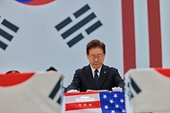 이재명 대통령이 6월 5일 성남 서울공항에서 열린 한·미 6·25전사자 유해 상호봉환식에서 봉송 유해에 전쟁 당시 미군 병사들이 고국의 가족들에게 보낸 기념품을 재현한 '아리랑 스카프'를 수여하고 있다.